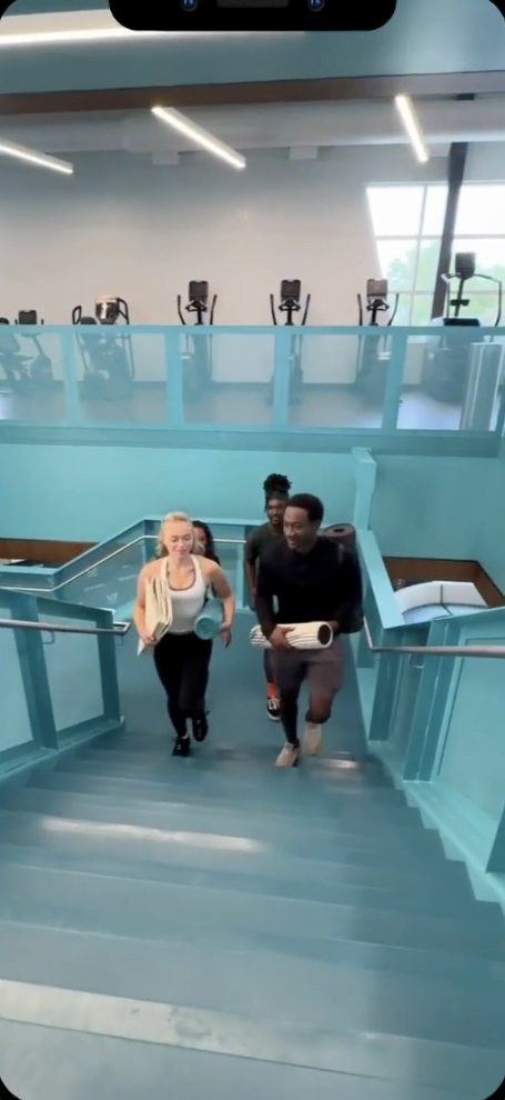 Two people walking up stairs at a gym