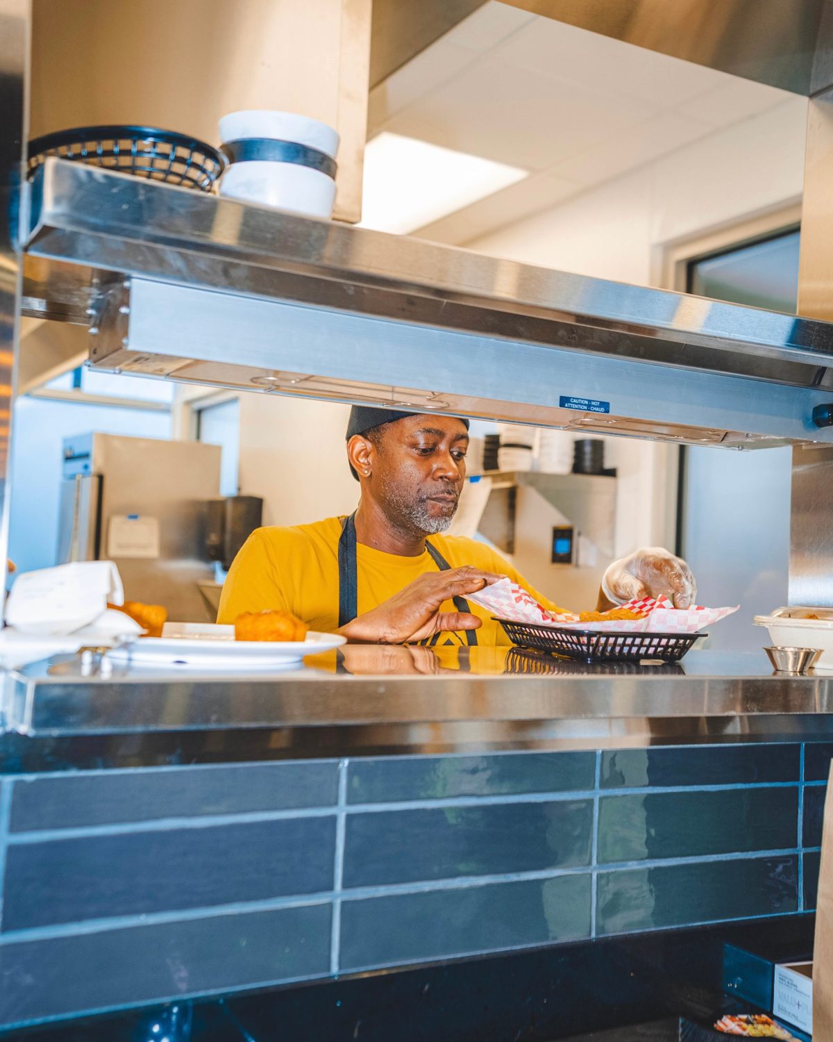 A cook plating food in the Soul Bowl kitchen
