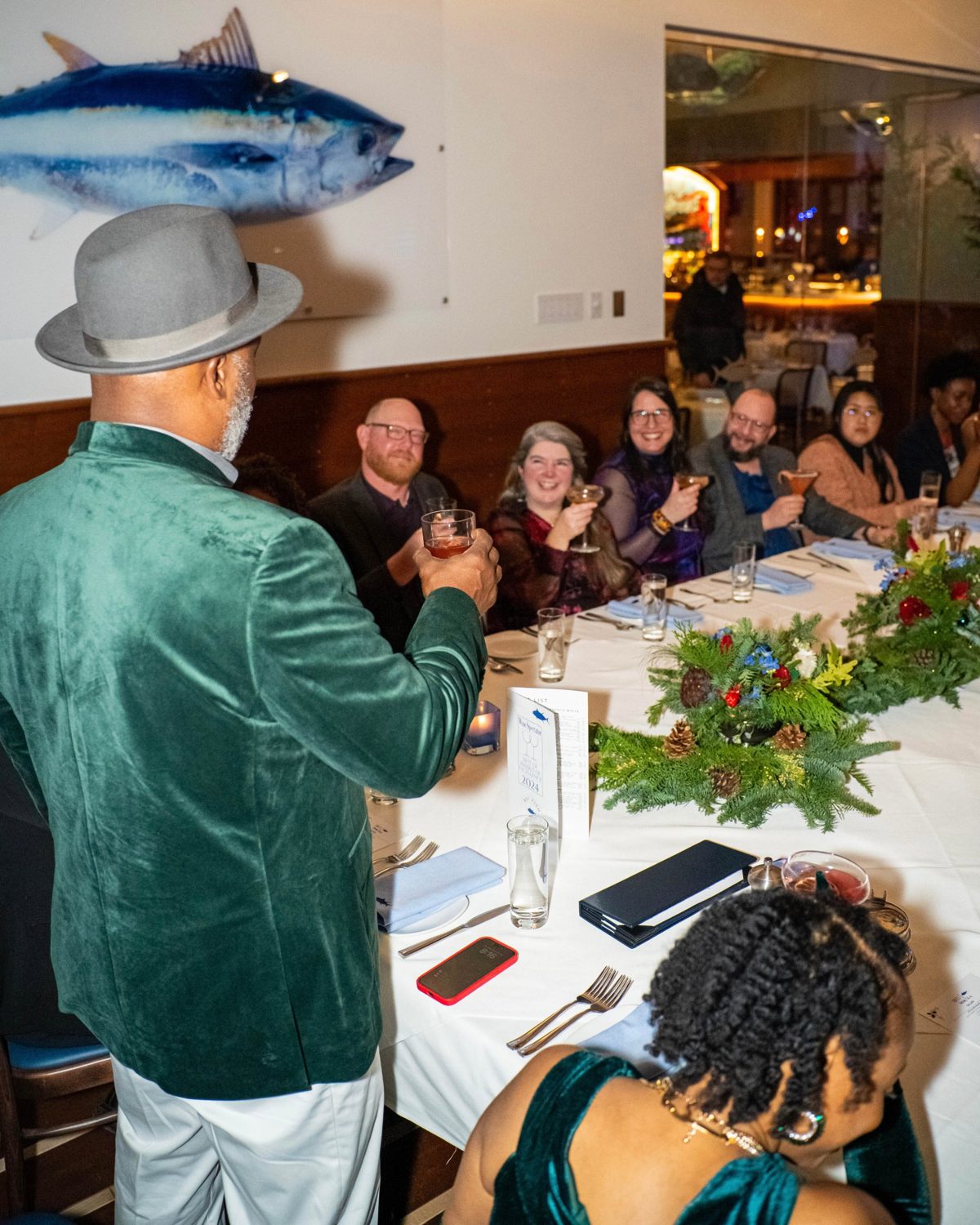 A guest raising a toast at a corporate holiday dinner